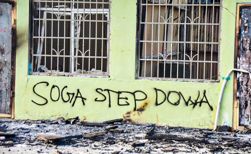 Anti-government messages adorn a burnt-out building in Honiara, Solomon Islands, on Nov. 27, 2021. (Charley Piringi/AFP via Getty Images)