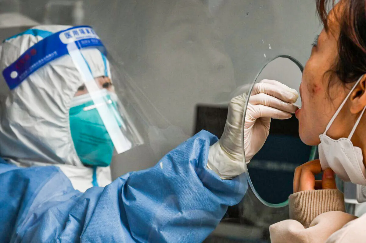 A woman is tested for COVID-19 near the Shanghai Jing'an Central Hospital in Shanghai, China on March 26, 2022. (HECTOR RETAMAL/AFP via Getty Images)