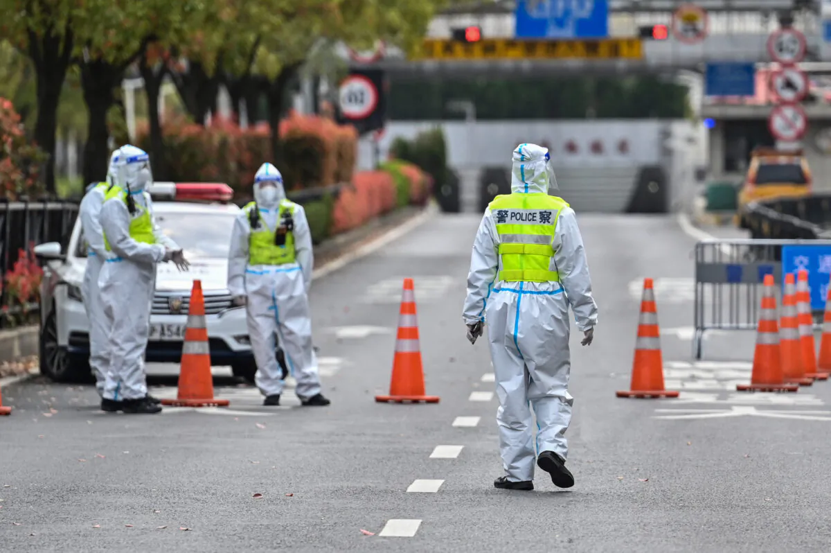 Police officers wearing protective gear control access to a tunnel in the direction of Pudong district in lockdown in Shanghai on March 28, 2022. (HECTOR RETAMAL/AFP via Getty Images)
