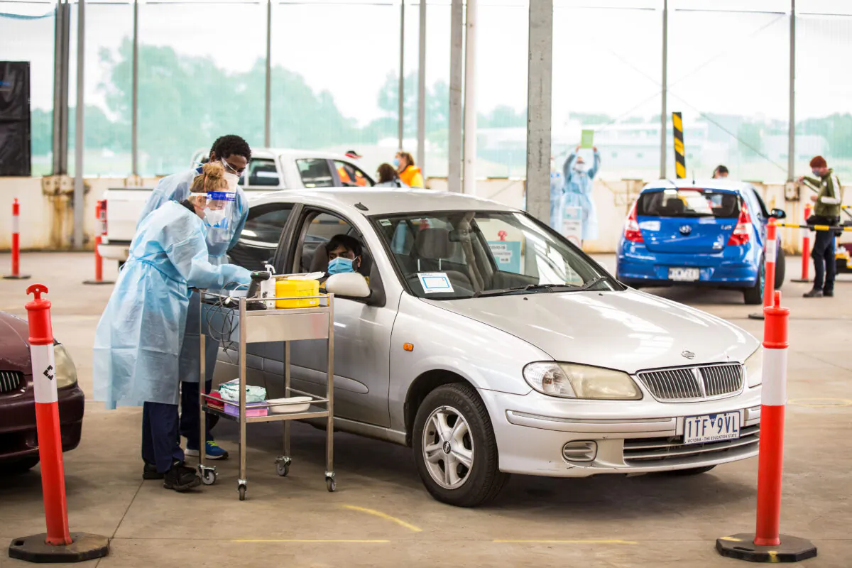 A nurse takes a man's information before administering the Pfizer COVID-19 vaccine at a drive through vaccination centre in Melbourne, Australia, on Aug. 9, 2021. (Darrian Traynor/Getty Images)