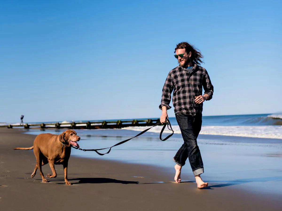 A man and his best friend take a lively stroll down Rehoboth Beach in Delaware. (Photo courtesy of South Delaware Tourism)