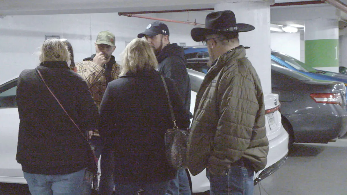 Oath Keepers founder Stewart Rhodes (R) looks on as Proud Boys chairman Enrique Tarrio (L) speaks with attorney Kellye SoRelle and others at a parking garage meeting in Washington on Jan. 5, 2021. Rhodes says he merely shook Tarrio’s hand and did not have any conversation. (Saboteur Media/Handout via REUTERS)
