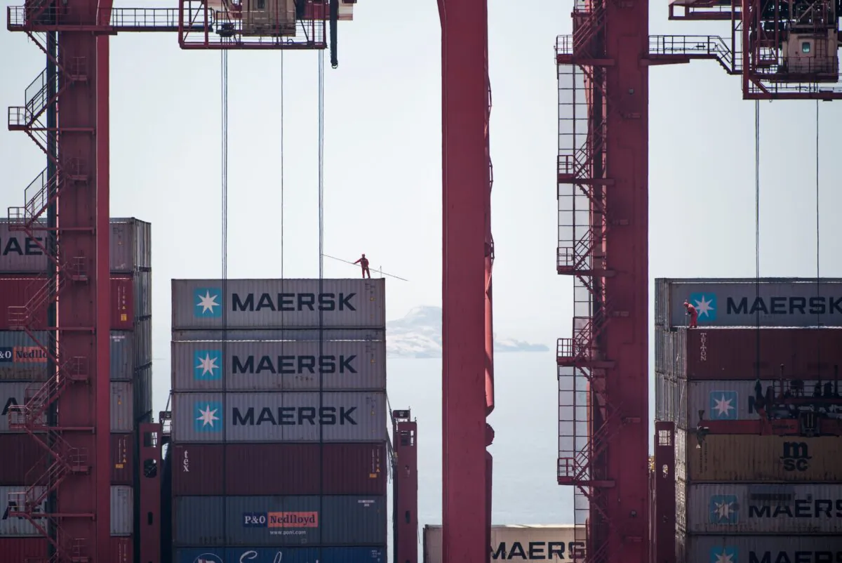A man (L) is working on an US cargo ship at the Yangshan Deep-Water Port in Shanghai on April 9, 2018. (JOHANNES EISELE/AFP via Getty Images)
