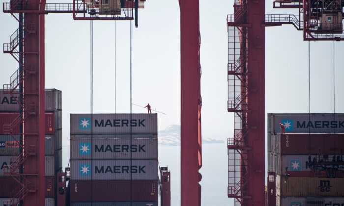 A man (L) is working on an US cargo ship at the Yangshan Deep-Water Port in Shanghai on April 9, 2018. (JOHANNES EISELE/AFP via Getty Images)