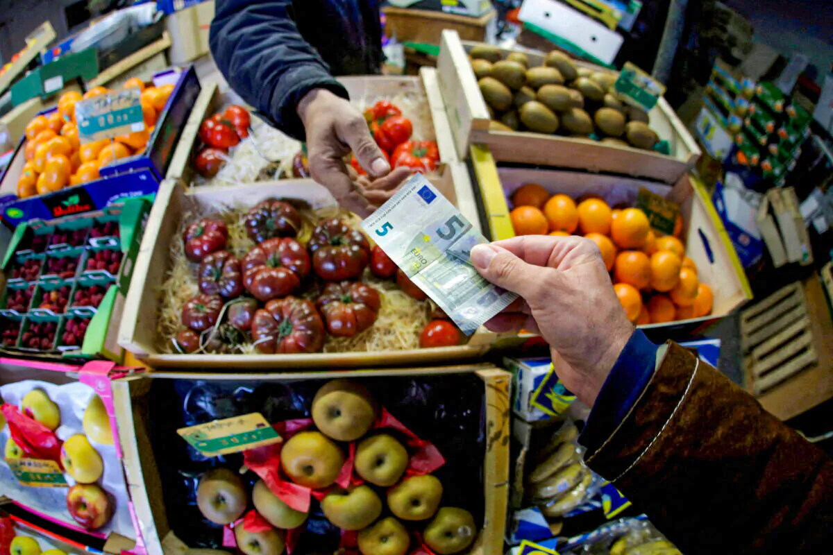 A shopper pays with a euro bank note in a market in Nice, France, on April 3, 2019. (Eric Gaillard/Reuters)