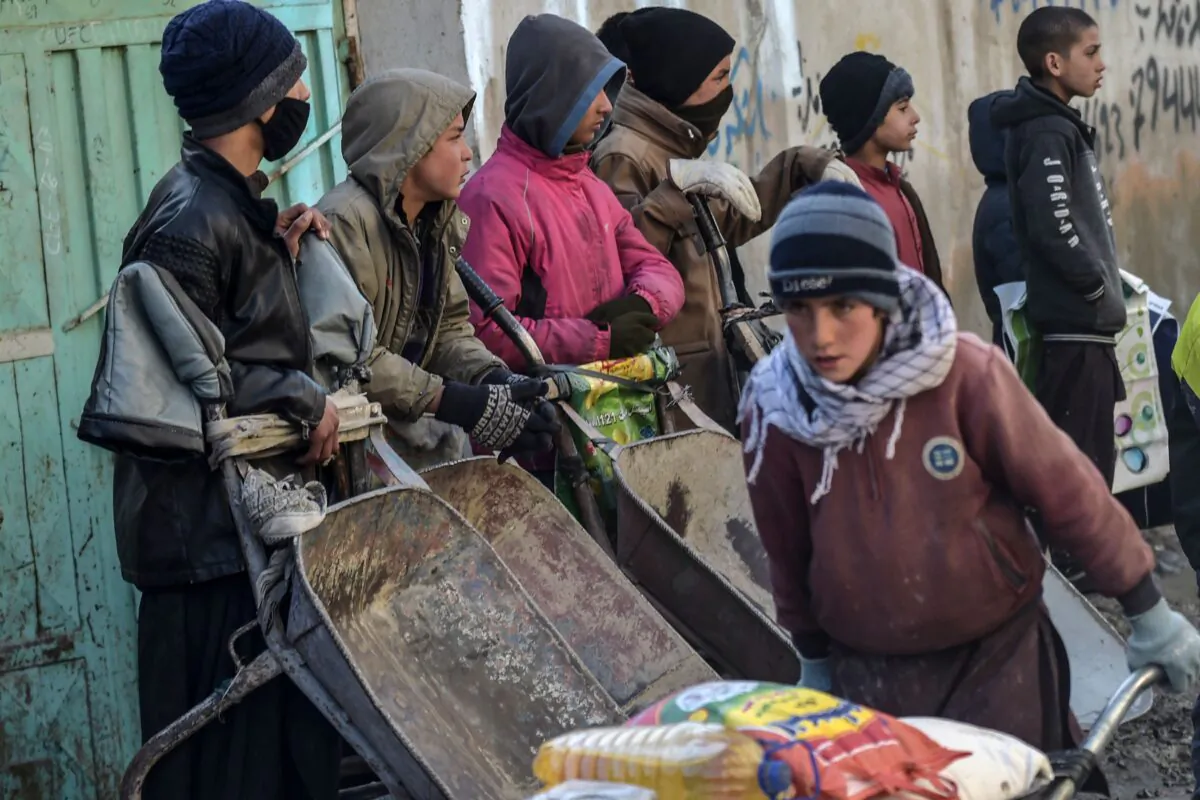 People wait to receive aid provided by a charity on the outskirts of Kabul on Jan. 30, 2022. (Wakil Kohsar/AFP via Getty Images)