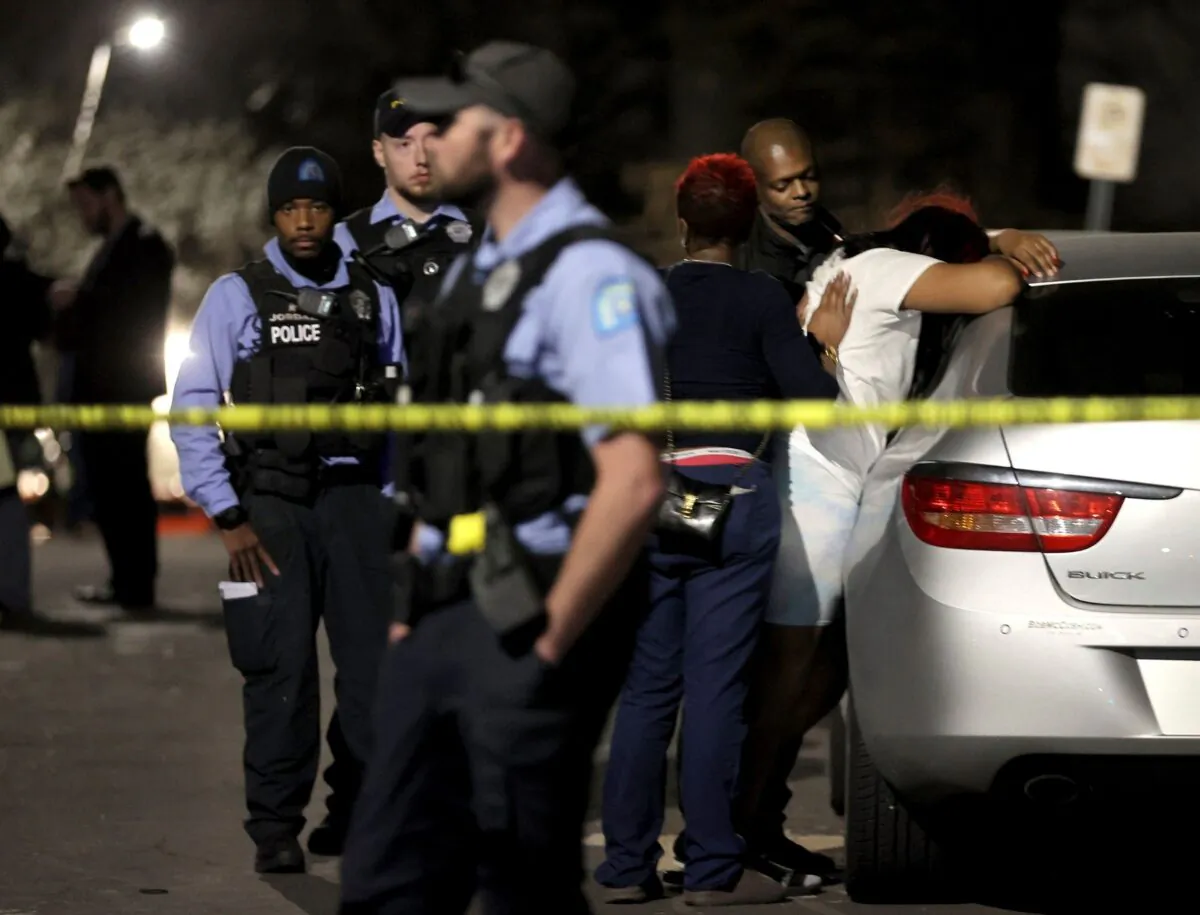 Family members of a deceased 12-year-old boy grieve at the scene where police say the child was shot and killed while playing with a gun that he and a 10-year-old found inside a home in St. Louis on March 29, 2022. (David Carson/St. Louis Post-Dispatch via AP)