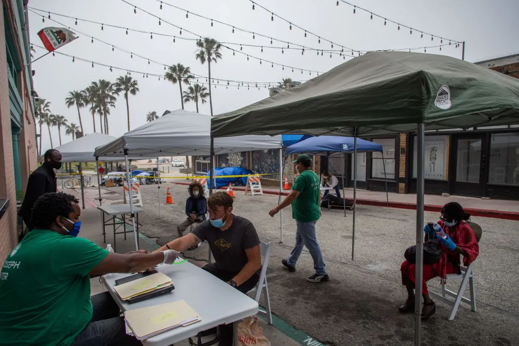 Homeless people wait to be checked into a hotel room in Venice Beach, Calif., on April 26, 2020. (Apu Gomes/AFP via Getty Images)