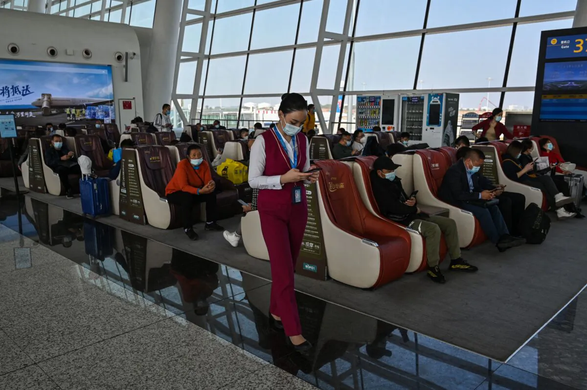 An airline worker checks her phone at the Tianhe International Airport in Wuhan, China, on Oct. 25, 2021. (Hector Retamal/AFP via Getty Images)