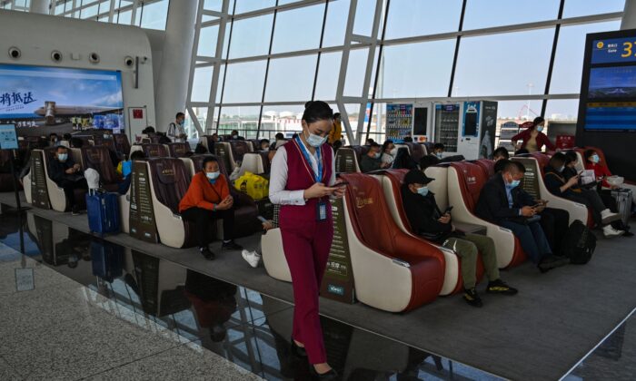 An airline worker checks her phone at the Tianhe International Airport in Wuhan, China, on Oct. 25, 2021. (Hector Retamal/AFP via Getty Images)