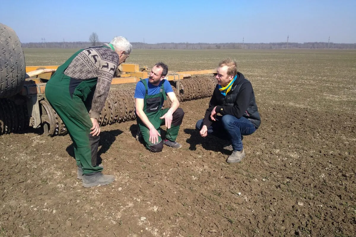 German farmers Tim Nandelstädt (C) and Torben Reelfs (R) inspect the field of their farm in Derzhiv, Ukraine, on March 23, 2022. (Tim Nandelstaedt/AFP via Getty Images)