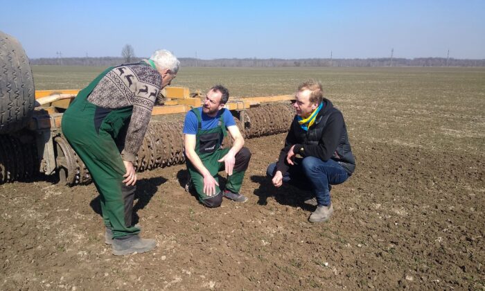 German farmers Tim Nandelstädt (C) and Torben Reelfs (R) inspect the field of their farm in Derzhiv, Stryi Raion, Lviv Oblast, western Ukraine on March 23, 2022. (Tim Nandelstaedt/AFP via Getty Images)