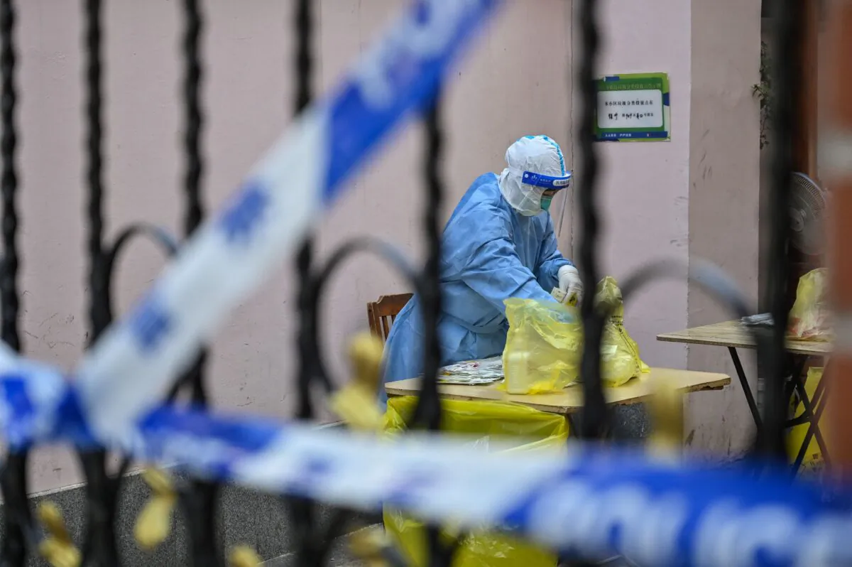 A health worker at a residential compound as people are tested for COVID-19 in Jing'an district in Shanghai, China, on March 29, 2022. (Hector Retamal/AFP via Getty Images)