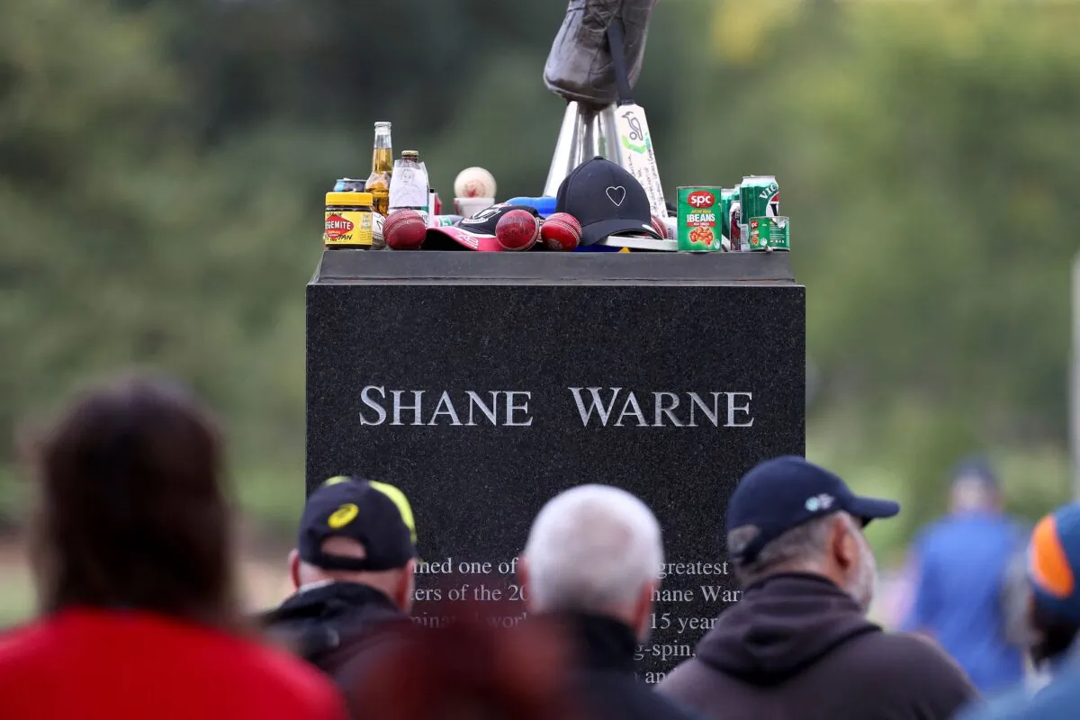 People gather around the statue of Shane Warne before the state memorial service for the former Australian cricketer Shane Warne at Melbourne Cricket Ground (MCG) in Melbourne, Australia, on March 30, 2022. (Aaron Franic/AFP via Getty Images)
