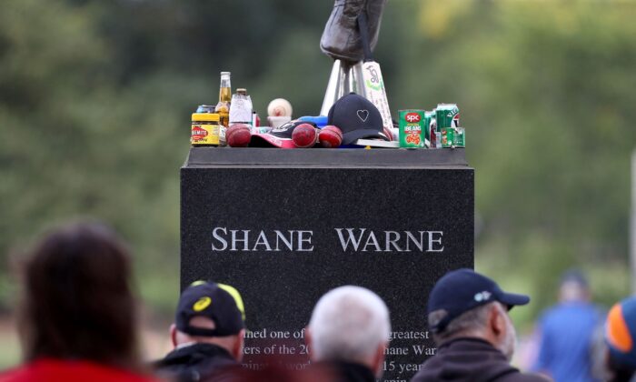 People gather around the statue of Shane Warne before the state memorial service for the former Australian cricketer Shane Warne at Melbourne Cricket Ground (MCG) in Melbourne, Australia, on March 30, 2022. (Aaron Franic/AFP via Getty Images)