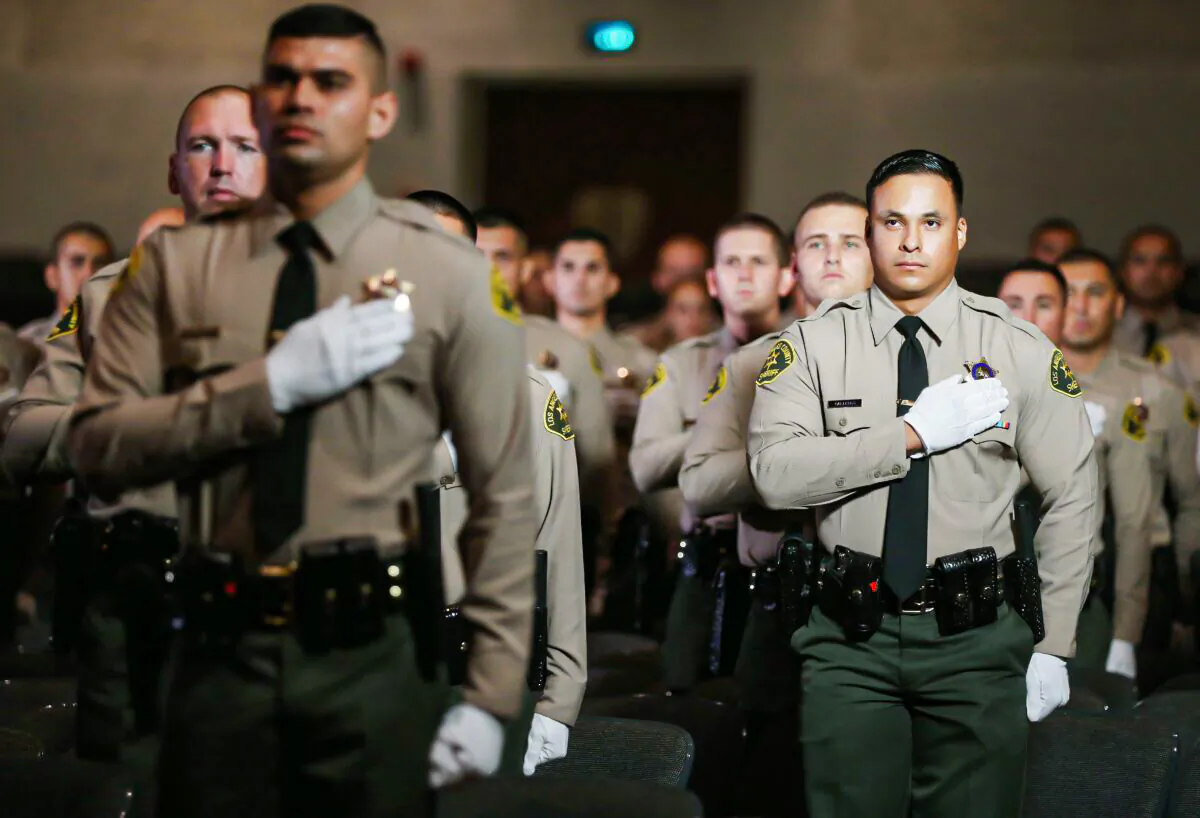 Graduates of Los Angeles County Sheriff's Department Academy Class 451 stand for the pledge of allegiance at their graduation ceremony at East Los Angeles College amid the COVID-19 pandemic in Monterey Park, Calif., on Aug. 21, 2020. (Mario Tama/Getty Images)