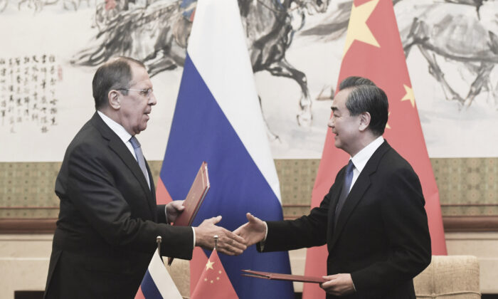 2018年4月23日，俄罗斯外长拉夫罗夫（左）与中国国务委员兼外交部长王毅（右）在中国北京钓鱼台国宾馆签字后握手。（共同社/池上圆）
