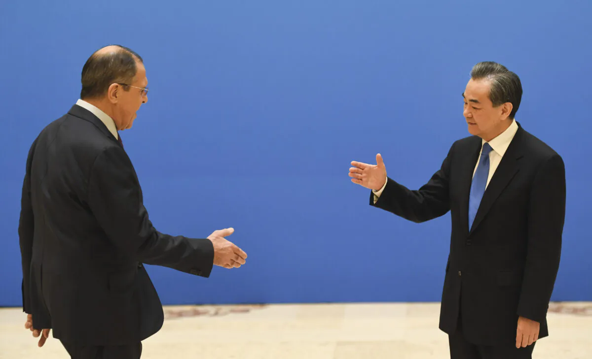 Russian Foreign Minister Sergei Lavrov (L) moves to shake hands with Chinese State Councilor and Foreign Minister Wang Yi before a meeting of foreign ministers and officials of the Shanghai Cooperation Organization (SCO) at the Diaoyutai State Guest House in Beijing on April 24, 2018. (Madoka Ikegami-Pool/Getty Images)