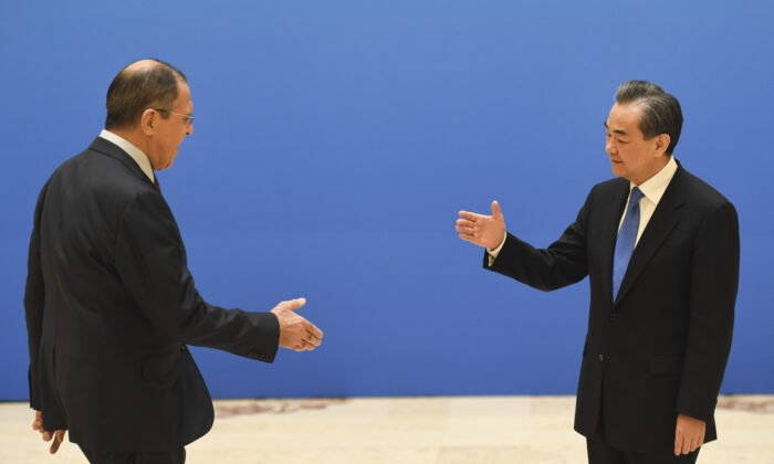 Russian Foreign Minister Sergei Lavrov (L) moves to shake hands with Chinese State Councilor and Foreign Minister Wang Yi before a meeting of foreign ministers and officials of the Shanghai Cooperation Organization (SCO) at the Diaoyutai State Guest House in Beijing on April 24, 2018.  (Madoka Ikegami-Pool/Getty Images)