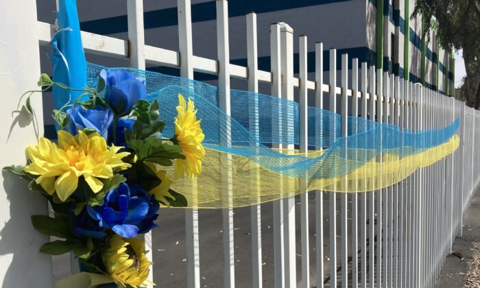A banner bearing the blue-and-yellow national colors of Ukraine is strung along a metal fence in Phoenix, Ariz., on March 26 following the Russian invasion of Ukraine in late February 2022. (Allan Stein/The Epoch Times)