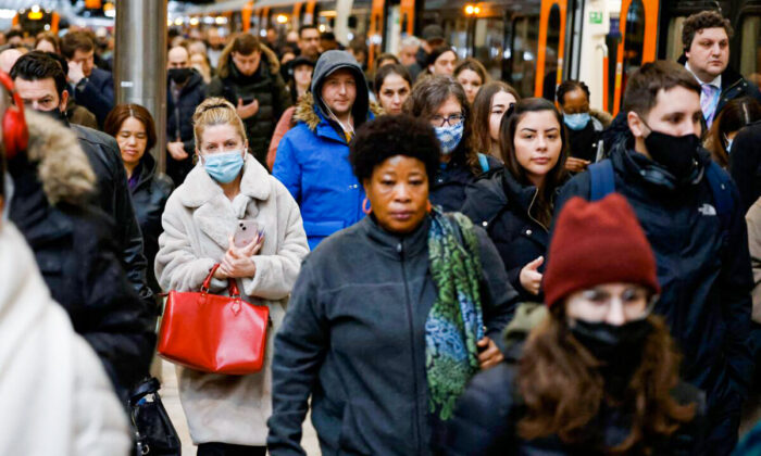 Commuters, some wearing face coverings due to COVID-19, exit a London Overground train service from Walthamstow, after arriving at Liverpool Street station in London on March 1, 2022. (Tolga Akmen /AFP via Getty Images)