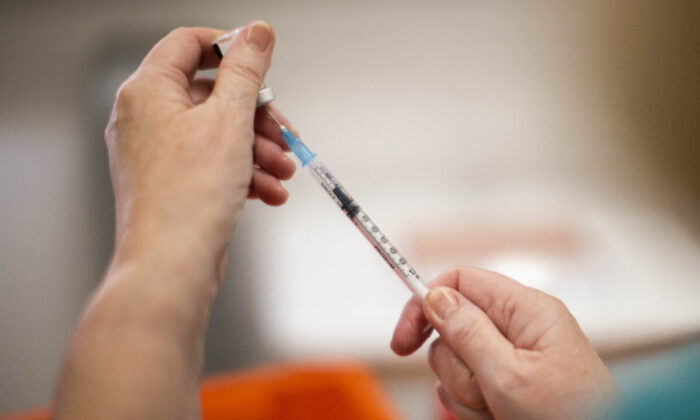 A file photo shows a worker preparing a COVID-19 vaccine. (Liam McBurney/PA Media)