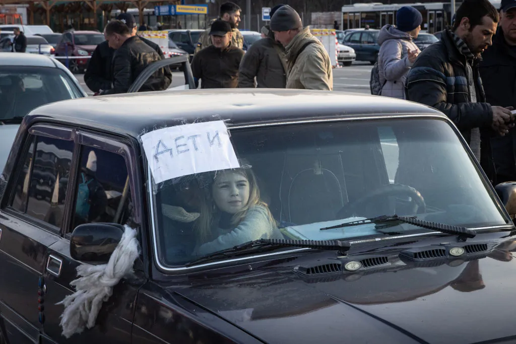 A girl waits in a car at an evacuation point in a convoy of cars and buses carrying hundreds of people evacuated from Mariupol and Melitopol, in Zaporizhzhia, Ukraine, on March 25, 2022. (Chris McGrath/Getty Images)