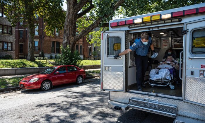 Louisville Metro EMS paramedics tend to a woman suspected of experiencing a severe COVID-19 emergency in an ambulance in Louisville, Ky., on Sept. 6, 2021. (Jon Cherry/Getty Images)
