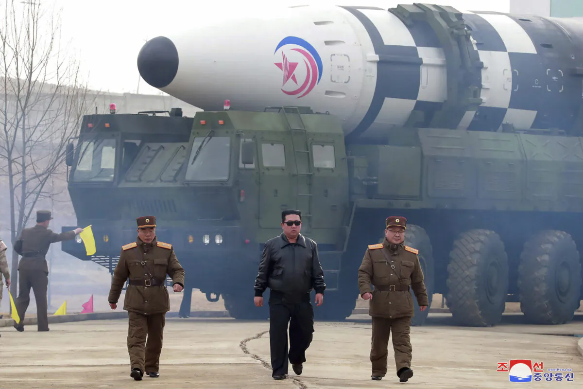 North Korean leader Kim Jong Un (C) walks around what it says a Hwasong-17 intercontinental ballistic missile (ICBM) on the launcher, at an undisclosed location in North Korea, on March 24, 2022. (Korean Central News Agency/Korea News Service via AP)