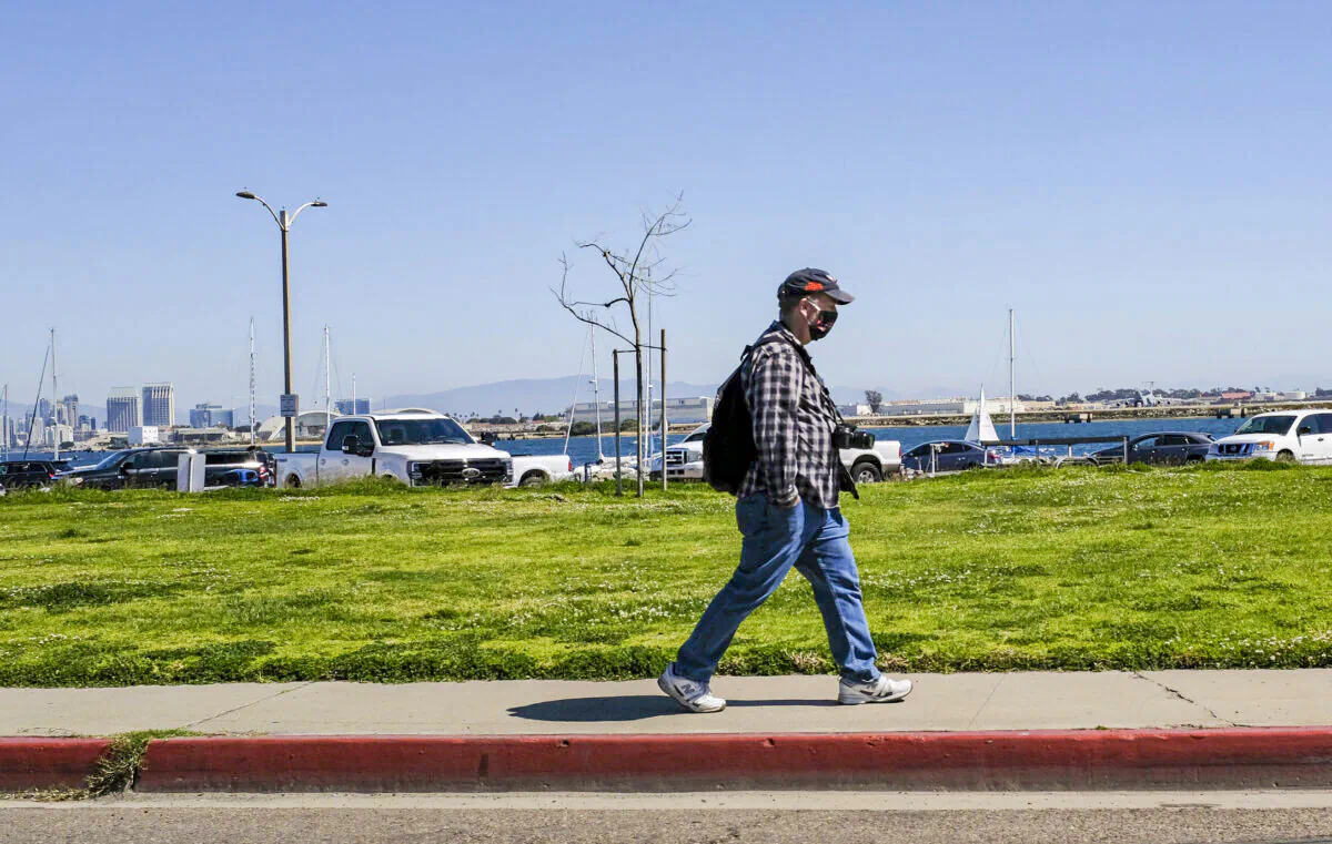 A pedestrian walks in San Diego, Calif., on March 27, 2021. (John Fredricks/The Epoch Times)