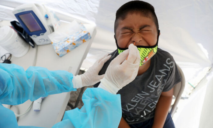 A boy receives a free COVID-19 test at a St. John’s Well Child & Family Center mobile clinic set up outside Walker Temple AME Church in South Los Angeles amid the coronavirus pandemic in Los Angeles, Calif., on July 15, 2020. (Mario Tama/Getty Images)