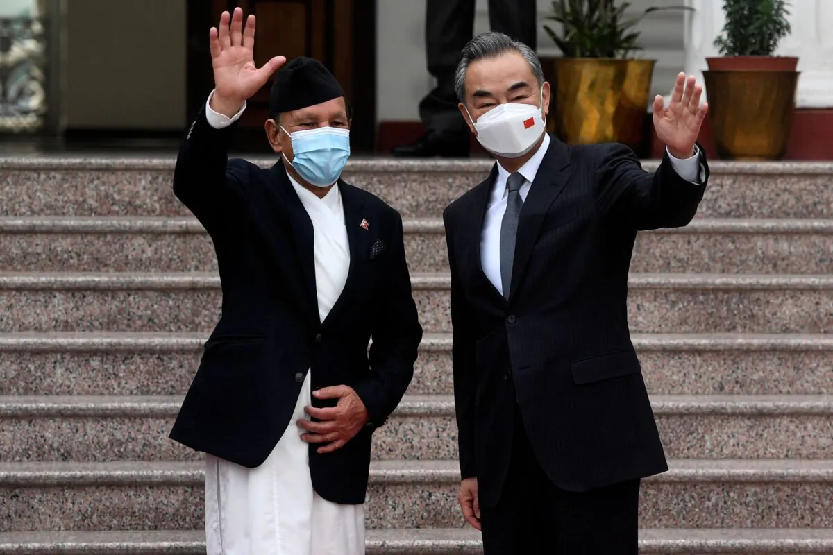 China's Foreign Minister Wang Yi (R) with Nepal's Foreign Minister Narayan Khadka wave before their meeting at Singhadurbar in Kathmandu, Nepal, on March 26, 2022. (Prakash Mathema/AFP via Getty Images)