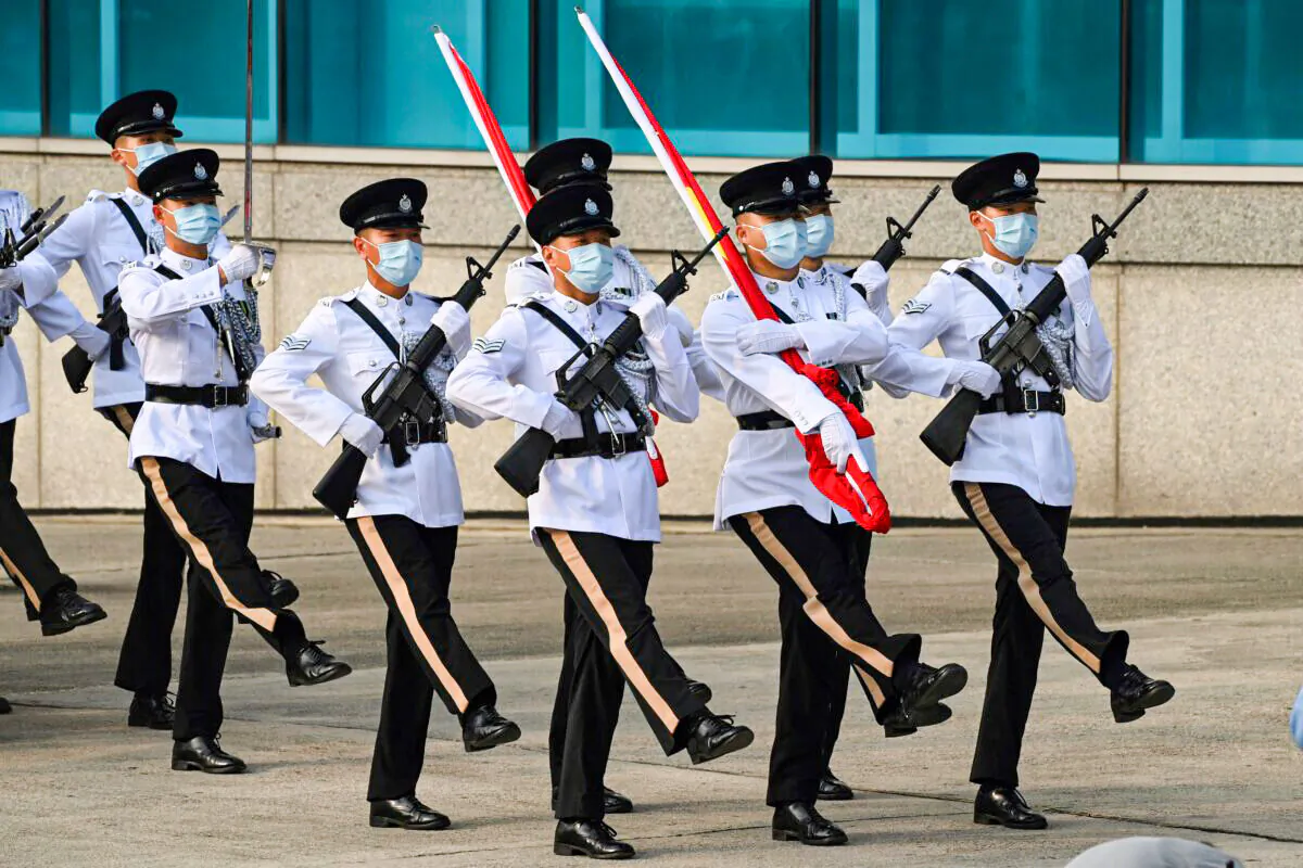Police officers goose-step carrying the Chinese and Hong Kong flags during a flag-raising ceremony to mark the 24th anniversary of Hong Kong's handover from Britain in Hong Kong on July 1, 2021. (Peter Parks/AFP via Getty Images)