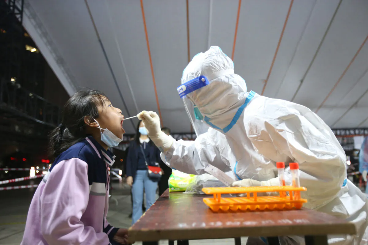 A child has a swab taken for nucleic acid test for COVID-19 in Xiamen, Fujian Province, on March 15, 2022. (STR/AFP via Getty Images)