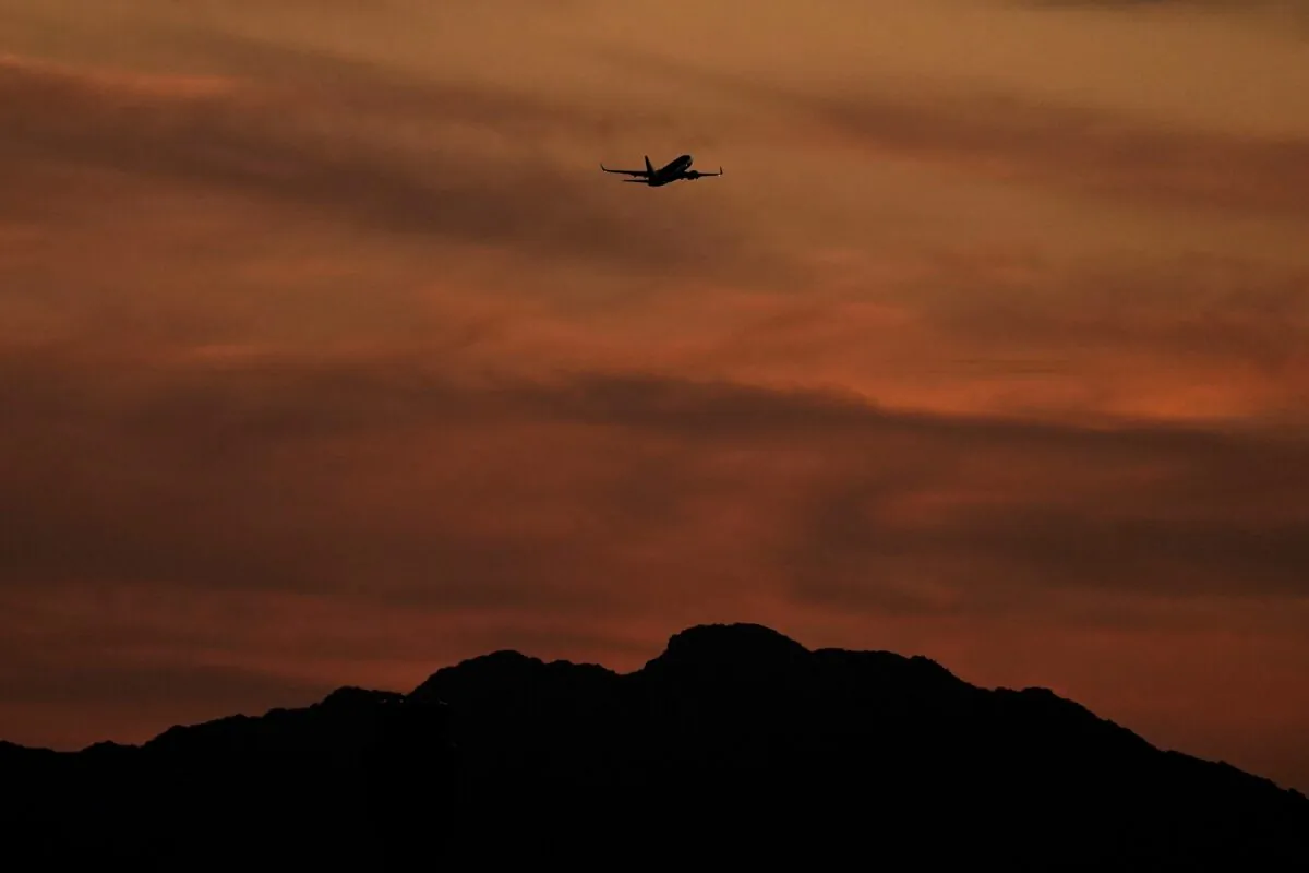 A passenger jet is silhouetted against the sky at dusk as it takes off from Sky Harbor Airport in Phoenix, on April 2, 2022. (Charlie Riedel/AP Photo)