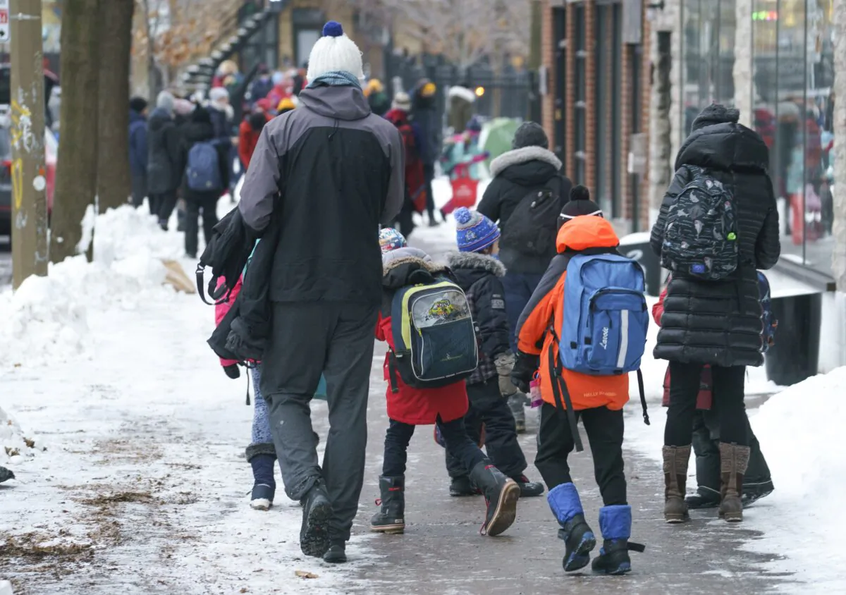 Parents walk their children to school in Montreal on Jan. 11, 2021. (Paul Chiasson/The Canadian Press)