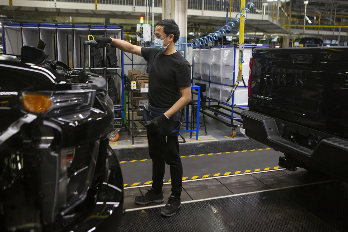 An auto worker is seen on the General Assembly line  producing the Chevrolet Silverado, at the GM plant  in Oshawa, Ontario, on  Feb. 22 2022. (The Canadian Press/Chris Young)