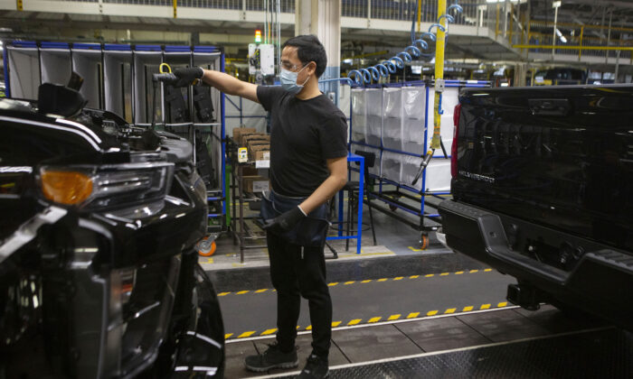 An auto worker is seen on the General Assembly line  producing the Chevrolet Silverado, at the GM plant  in Oshawa, Ontario, on  Feb. 22 2022. (The Canadian Press/Chris Young)