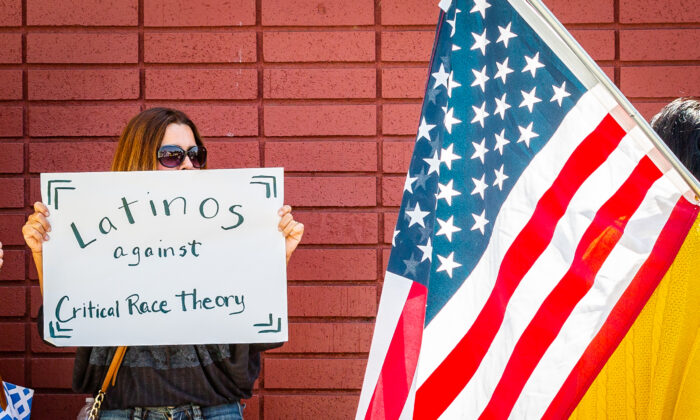A woman holds a sign against critical race theory in Los Alamitos, Calif., on May 11, 2021. (John Fredricks/The Epoch Times)
