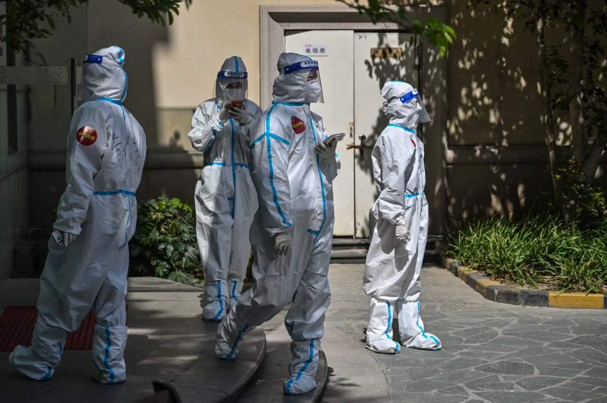 Workers in a compound where residents are being tested for COVID-19 during the second stage of a pandemic lockdown in Jing'an district in Shanghai on April 4, 2022. ( Hector Retamal/AFP via Getty Images)