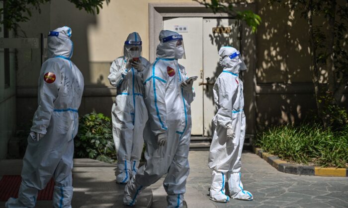 Workers in a compound where residents are being tested for COVID-19 during the second stage of a pandemic lockdown in Jing'an district in Shanghai on April 4, 2022. ( Hector Retamal/AFP via Getty Images)