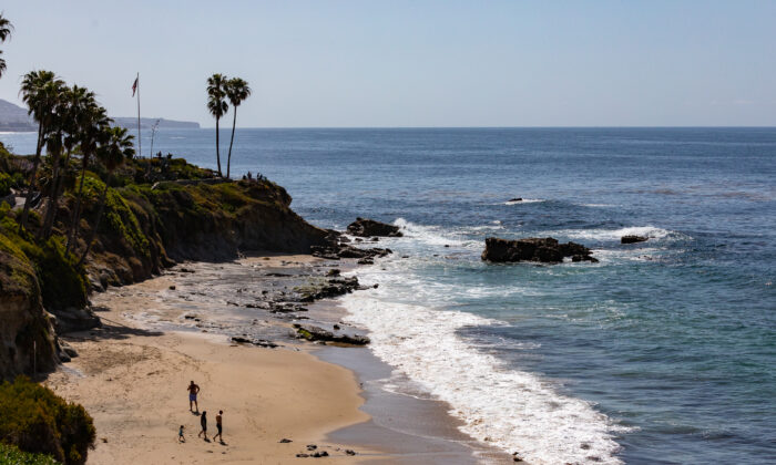 People enjoy the beach in Laguna Beach, Calif., on March 30, 2022. (John Fredricks/The Epoch Times)