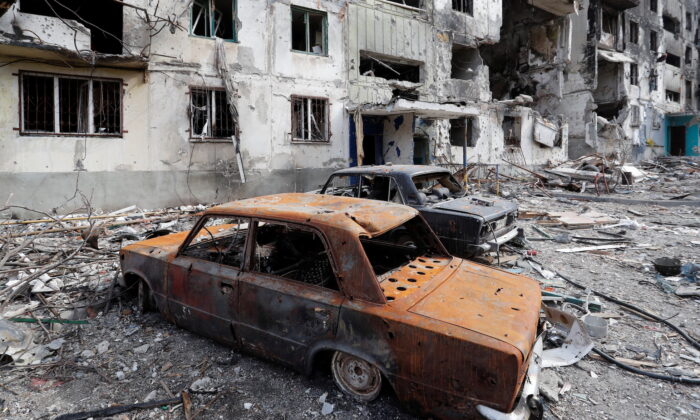 2022 年 4 月 3 日，在乌克兰马里乌波尔的乌俄冲突中，一座公寓楼前被毁坏的汽车残骸。（Alexander Ermochenko/路透社）