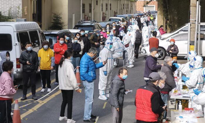 People line up to give a sample for nucleic acid testing at a residential block during a citywide COVID-19 nucleic acid testing campaign on April 1, 2022 in Shanghai, China. (Zhang Suoqing/VCG via Getty Images)