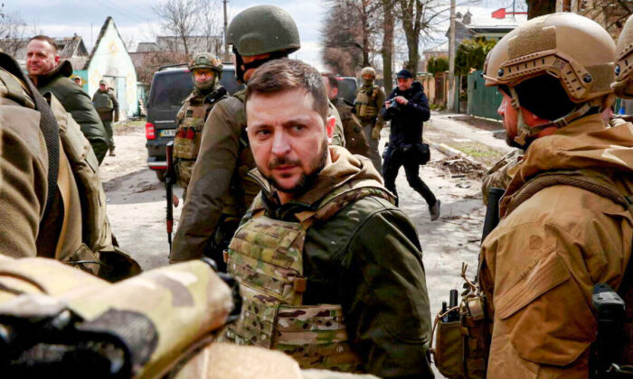 Ukraine's President Volodymyr Zelenskyy looks on as he's surrounded by Ukrainian servicemen in Bucha, outside Kyiv, Ukraine, on April 4, (2022. REUTERS/Marko Djurica)