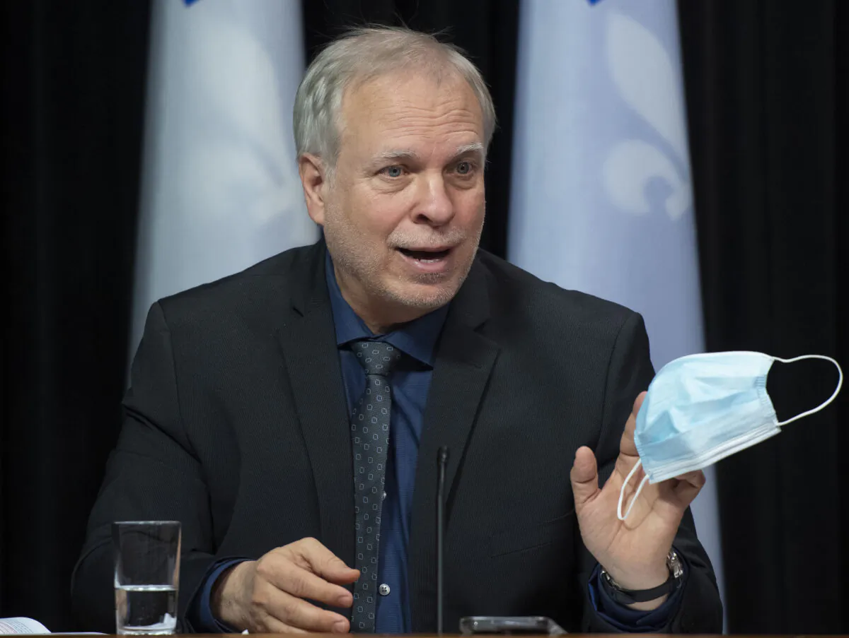 Luc Boileau, Quebec interim director of National Public Health holds a mask as he responds to reporters during a news conference on the COVID-19 pandemic, on Feb. 16, 2022 at the legislature in Quebec City. (The Canadian Press/Jacques Boissinot)