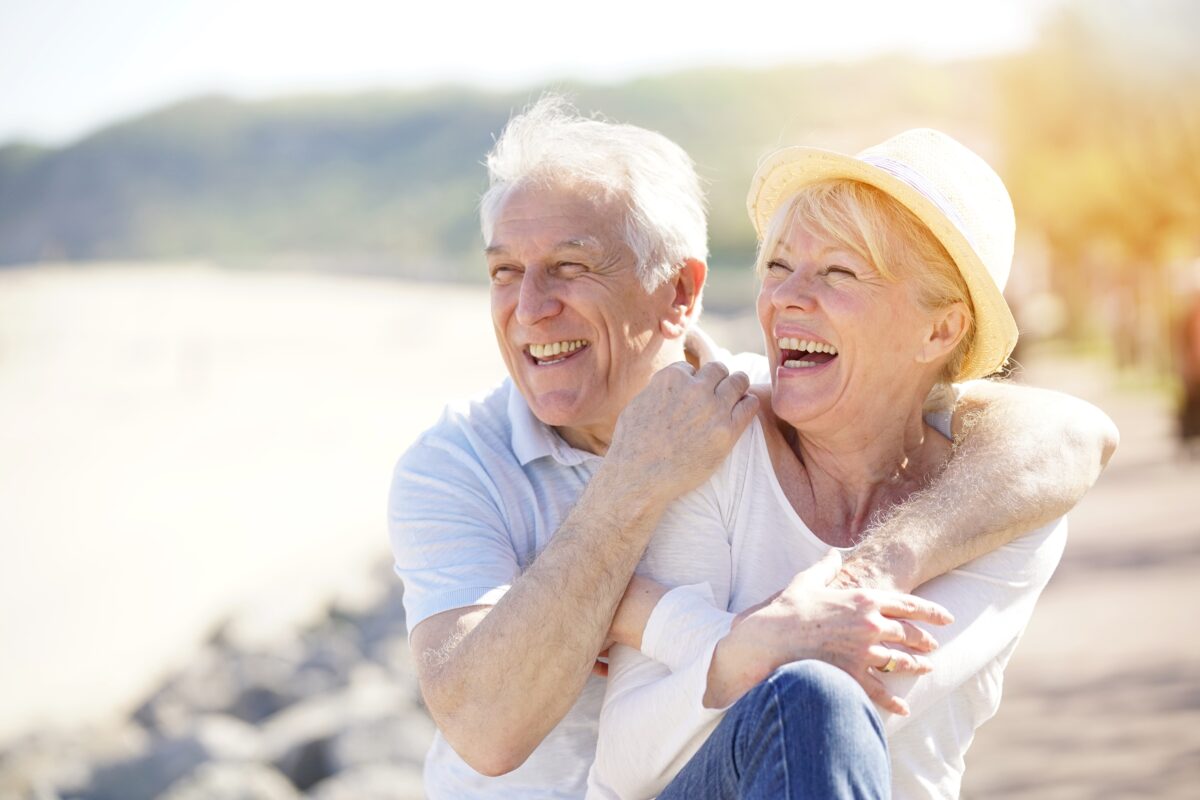Senior couple relaxing by the sea on sunny day. (goodluz/Shutterstock)