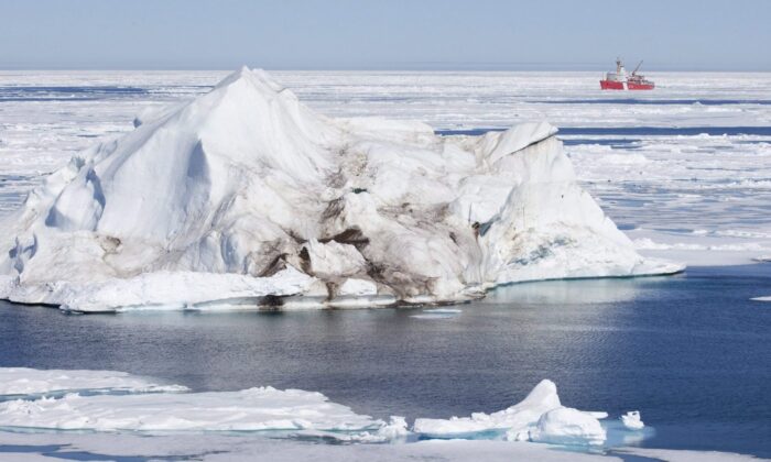 A iceberg floating in the Baffin Bay above the arctic circle dwarfs the Canadian Coast Guard icebreaker Louis S. St-Laurent July 10, 2008. (The Canadian Press/Jonathan Hayward)