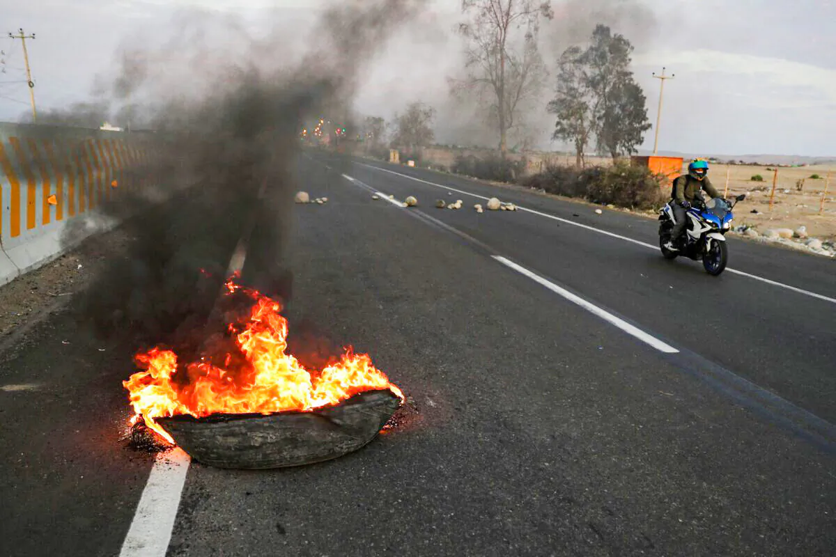 A burning tire serves as part of a blockade of a highway to Lima during a national transportation strike in Ica, Peru, on April 4, 2022. (Sebastian Castaneda/Reuters)