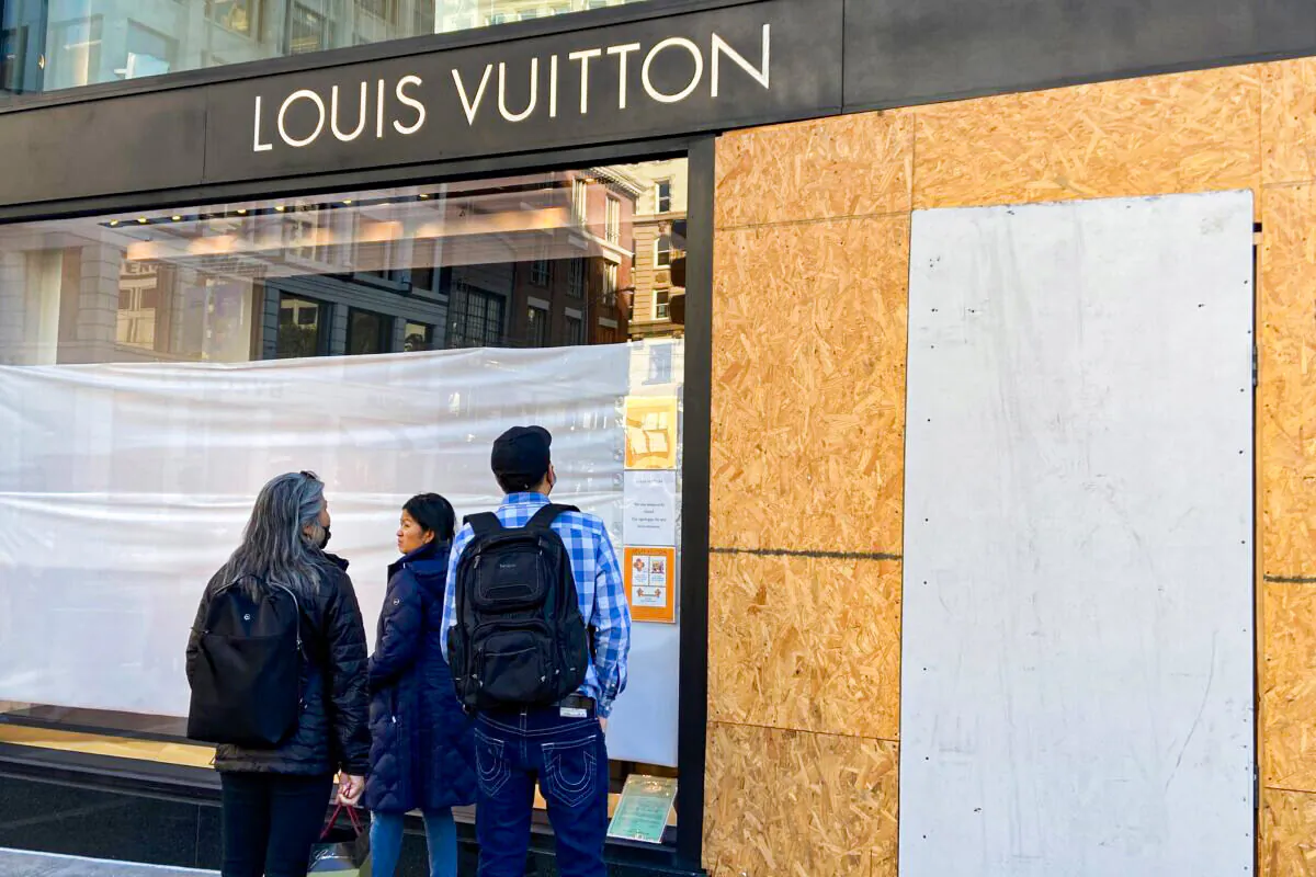 Union Square visitors look at damage to a Louis Vuitton store in San Francisco on Nov. 21, 2021. (Danielle Echeverria/San Francisco Chronicle via AP)